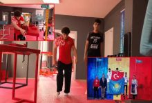 Görselde, milli sporcu Raşid Mavigil'in bir spor salonunda antrenman yaptığı görülüyor. Doğuştan bedensel engeli bulunan Mavigil, özel ekipmanlarla çalışmalarını sürdürüyor. Görselin sağ alt kısmında ise uluslararası bir organizasyonda madalya kürsüsünde yer aldığı an bulunuyor. Fotoğraf, sporcunun antrenman süreci ile elde ettiği sportif başarıları bir arada yansıtıyor.
