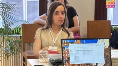 Elif Nur Aybaş'ın konuşmacı olarak yer aldığı atölye oturumunda katılımcılar sunumu dinliyor. Ön planda masanın üzerinde açık bir dizüstü bilgisayar ve kahve bardağı bulunurken, arka planda pencere önünde oturan katılımcılar görülüyor. Atölye BİA logosu görselin sağ üst köşesinde yer alıyor.