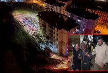 Görsel, gece saatlerinde meydana gelen bir olaya ilişkin haber fotoğrafı niteliğinde. Fotoğrafın ana bölümünde çok katlı bir apartmanın çevresi havadan görüntülenmiş; bina önünde itfaiye ve acil durum araçları ile toplanan kalabalık dikkat çekiyor. Bölge kırmızı ve mavi acil durum ışıklarıyla aydınlatılmış durumda. Sağ alt köşedeki ek karede ise iki kişinin destek verdiği yaşlı bir erkek görülüyor. Yaşlı kişinin üzgün ve endişeli bir ifade taşıdığı, çevresinde maske takan görevlilerin bulunduğu seçiliyor. Görsel genel olarak bir yangın veya acil müdahale sonrası yaşanan gelişmeleri yansıtan haber fotoğrafı izlenimi veriyor.