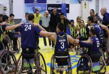 Fenerbahçe İstanbul Jet Tekerlekli Sandalye Basketbol Takımı oyuncuları ve teknik ekibi, çember oluşturup omuz omuza vererek takım ruhunu yansıtan coşkulu bir an yaşamaktadır.