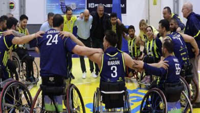 Fenerbahçe İstanbul Jet Tekerlekli Sandalye Basketbol Takımı oyuncuları ve teknik ekibi, çember oluşturup omuz omuza vererek takım ruhunu yansıtan coşkulu bir an yaşamaktadır.
