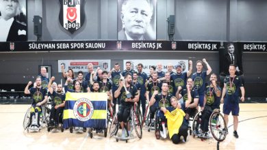 Görsel, Beşiktaş’ın Süleyman Seba Spor Salonu’nda düzenlenen organizasyonun ardından, kupaları ve madalyalarıyla büyük bir coşku içinde zaferlerini kutlayan tekerlekli sandalye basketbol takımının, Fenerbahçe bayrağı eşliğinde toplu hatıra pozu verdiği gurur dolu bir anı yansıtmaktadır.
