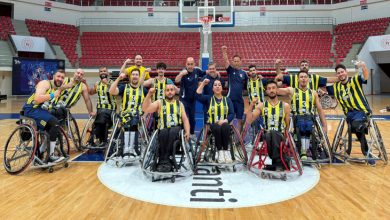 Fenerbahçe İstanbul Jet Tekerlekli Sandalye Basketbol Takımı oyuncuları ve teknik heyet sağ yumruk sıkarak poz veriyor.