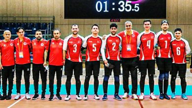 Goalball Erkek Milli Takımı teknik heyetle sahada poz veriyor.
