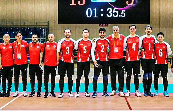 Goalball Erkek Milli Takımı teknik heyetle sahada poz veriyor.