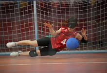 Kadın Goalball Milli Takımın dört numaralı sporcusu soluna yatarak topu kurtarıyor.
