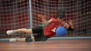 Kadın Goalball Milli Takımın dört numaralı sporcusu soluna yatarak topu kurtarıyor.