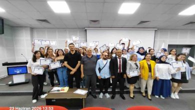 Bir konferans salonunda çekilen toplu fotoğrafta, çok sayıda genç ellerinde sertifikalarıyla poz veriyor. Ön sırada eğitmenler ve organizasyon temsilcileri yer alırken, katılımcılar başarılarını kutlayan neşeli bir görünüm sergiliyor. Görsel, eğitim programının tamamlanması sonrasında düzenlenen sertifika törenini yansıtıyor.
