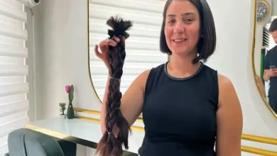 Özlem Deniz elinde bağışladığı kesilen örgülü saçlarını tutuyor.