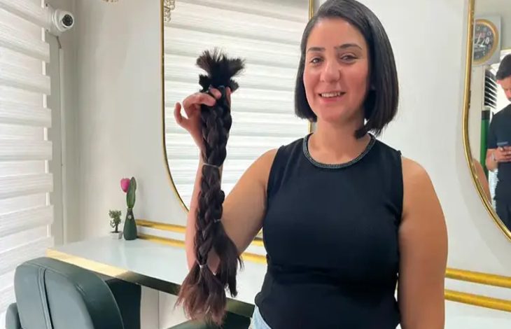 Özlem Deniz elinde bağışladığı kesilen örgülü saçlarını tutuyor.