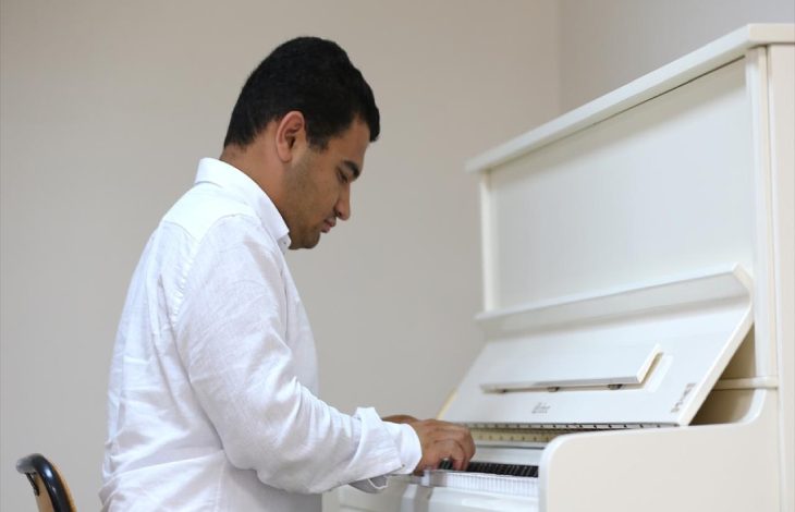 Otizmli müzik öğretmenliği Ertuğrul Gök, piyano çalıyor.