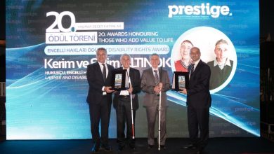 Görselde, bir ödül töreni sahnesinde dört kişi plaketlerle poz veriyor. Arka plandaki ekranda 20. Yaşama Değer Katanlar Ödül Töreni ve Engelli Hakları Ödülü ifadeleri yer alırken, hukukçu Kerim ve Selim Altınok adına yapılan ödül takdimi öne çıkıyor. Resmî ve kutlama atmosferi yansıtılıyor.
