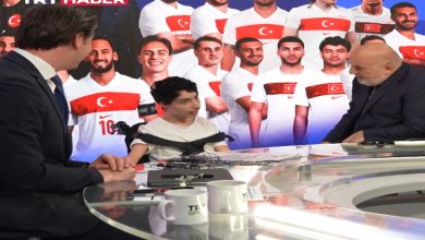 Bir televizyon stüdyosunda gerçekleşen yayında, genç bir çocuk masada sunucularla sohbet ediyor. Arka planda Türkiye forması giymiş sporcuların büyük görselleri yer alırken, TRT Haber logosu ekranda görünüyor. Spor odaklı sıcak ve samimi bir yayın anı yansıtılıyor.
