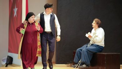 Bir tiyatro sahnesinde üç oyuncunun yer aldığı bir oyun sahnesi görülüyor. Oyuncular karakterlerini canlandırırken, sahnenin bir köşesinde koltuk değneği kullanan bir karakter dikkat çekiyor. Türk bayrağının da yer aldığı dekor eşliğinde sergilenen oyun, engelli bireylerin sanatsal üretimdeki yerini ve toplumsal farkındalık çalışmalarını yansıtıyor.