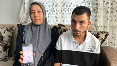 Bir kadın ve genç bir erkek ev ortamında yan yana oturuyor. Kadın elindeki cep telefonunda resmi bir belgeyi gösterirken, ikisi de kameraya bakıyor. Görsel, doğuştan engelli Hasan'a 20 yıl sonra "engelli değildir" raporu verilmesine ilişkin haberi temsil ediyor.