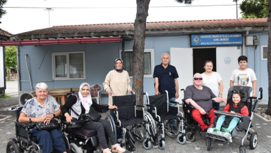 Karadeniz Omurilik Felçlileri Derneği önünde çekilen fotoğrafta, tekerlekli sandalye ve akülü sandalye kullanan bireyler ile yakınları, teslim edilen tekerlekli sandalyelerle birlikte toplu halde objektife poz veriyor. Arka planda dernek binasının girişi ve tabelası yer alıyor.