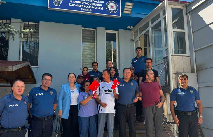 Kocatepe Polis Merkezi Amirliği önünde çekilen fotoğrafta, otizmli çocuklar, aileleri ve polis memurları bir araya geliyor. Grup, Türk bayraklarıyla objektife poz verirken, ziyaret anısı toplu fotoğrafla ölümsüzleştiriliyor.