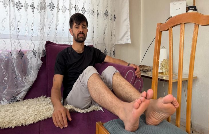 Şerif Osman koltukta bulunup, ayaklarını sandalyeye uzatarak oturuyor.
