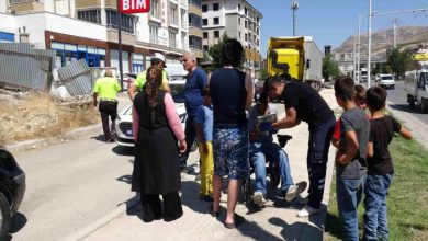 Akülü sandalyede bulunan yayanın etrafında vatandaşlar ve polis memurları bulunuyor.
