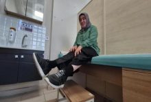 Muayene odasında bulunan Melek Kandil, sedyede otururken ayakkabısı ile basamak merdiven üstünde poz veriyor.