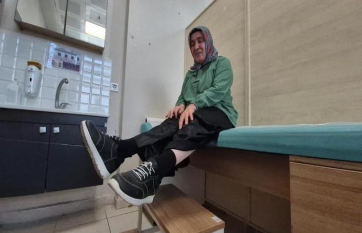 Muayene odasında bulunan Melek Kandil, sedyede otururken ayakkabısı ile basamak merdiven üstünde poz veriyor.