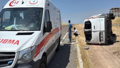 Devrilen servis aracının yanında ambulans bulunuyor.
