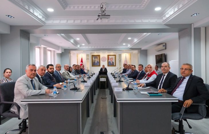 Karaman Valisi Hayrettin Çiçek başkanlığında gerçekleştirilen toplantıda, uzun bir konferans masasının iki yanında kamu kurumlarının temsilcileri yer alıyor.