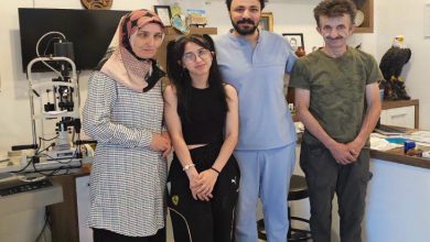 Göz Hastalıkları Uzmanı Op. Dr. M. Celal Öcal, kliniğinde aileyle ayakta durarak poz veriyor.
