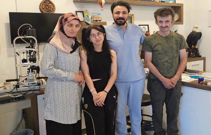 Göz Hastalıkları Uzmanı Op. Dr. M. Celal Öcal, kliniğinde aileyle ayakta durarak poz veriyor.