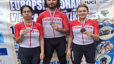 Milli para bisikletçi Fırat Uğur ortada, Tuana Filiz ve pilotu Ayça Erdoğan iki tarafında durarak madalyaları tutarak poz veriyorlar.