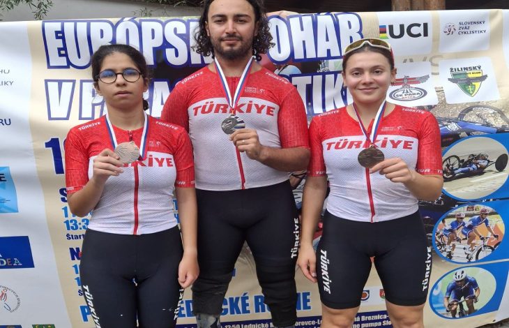 Milli para bisikletçi Fırat Uğur ortada, Tuana Filiz ve pilotu Ayça Erdoğan iki tarafında durarak madalyaları tutarak poz veriyorlar.