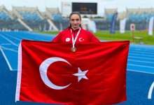 Milli Sporcu Elif Bayar, Türk bayrağı tutarak poz veriyor.