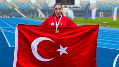 Milli Sporcu Elif Bayar, Türk bayrağı tutarak poz veriyor.