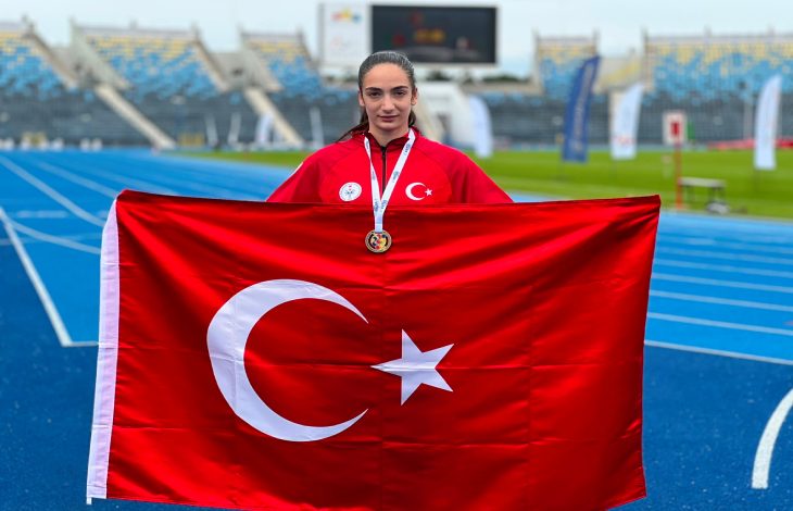 Milli Sporcu Elif Bayar, Türk bayrağı tutarak poz veriyor.