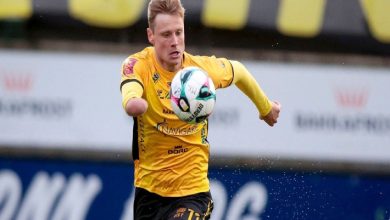 Runavik forması giyen sağ kolu ampute futbolcu Marius Lindh, göğsünün önünde top sürüyor.