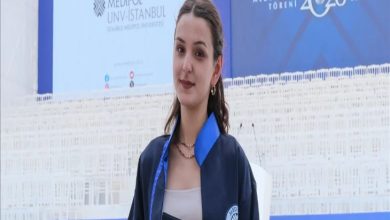 Görselde, mezuniyet cübbesi ve diplomasıyla poz veren genç bir kadın yer alıyor. Arka planda "2026 Mezuniyet Töreni" yazılı sahne, İstanbul Medipol Üniversitesi logosu ve tören alanındaki beyaz sandalyeler görülüyor. Kadın kameraya gülümseyerek bakarken, mezuniyet töreni atmosferi öne çıkıyor.
