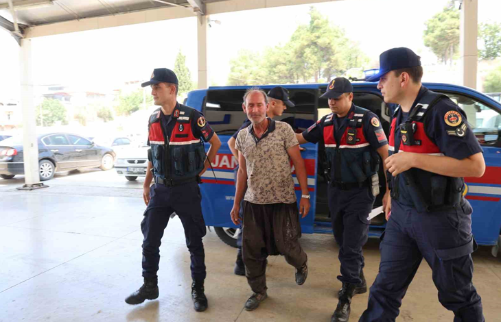 Fotoğrafta, jandarma ekipleri tarafından bulunan Uğur Okuducu iki görevlinin eşliğinde yürürken görülüyor. Arka planda bir jandarma aracı bulunurken, ekipler sağlık kontrolü ve işlemler için kendisini binaya götürüyor.