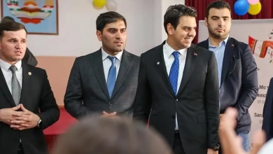 Fotoğrafta, resmi kıyafetli dört kişi sınıf ortamında bir etkinliğe katılırken görülüyor. Takım elbise ve kravat giyen heyet üyeleri ayakta dururken, ön planda çocukların bulanık şekilde görünen başları yer alıyor. Sınıfın duvarlarında renkli balonlar ve çocuklara yönelik süslemeler bulunuyor. Haber, TİKA'nın Tacikistan'da işitme engelli çocukların eğitim ve sanatsal gelişimini desteklemek amacıyla hayata geçirdiği erişilebilir eğitim projesini konu alıyor.