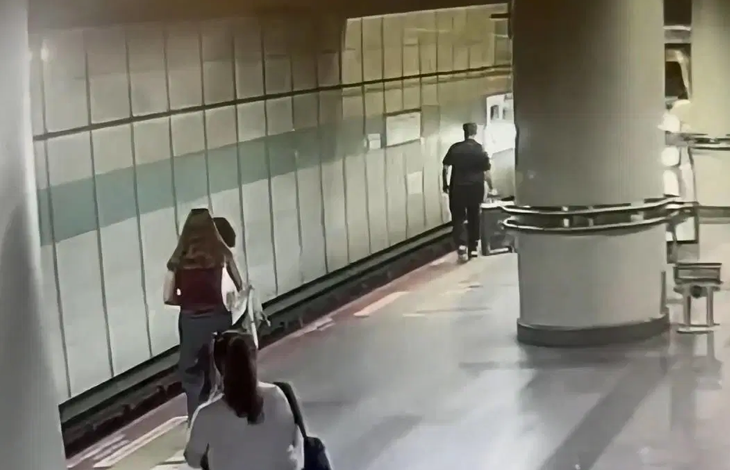 Güvenlik kamerası görüntüsünde, bir metro istasyonunun peronunda yolcular görülüyor. Peronun raylara yakın bölümünde ilerleyen bir kişi yer alırken, diğer yolcular arkadan geliyor. Haber, Şişli’de görme engelli Enes’in valiziyle birlikte metro raylarına düşmesini konu alıyor.