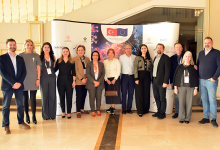 Atabay Biyoteknoloji ekibi, TÜBİTAK ve Avrupa Birliği logolarının yer aldığı bilimsel temalı büyük bir tanıtım panosu önünde toplu halde poz veriyor. On iki kişilik ekip, resmi bir toplantı veya proje etkinliği kapsamında bir araya gelmiş izlenimi veriyor; ortam ferah, kurumsal ve profesyonel bir salon görünümünde.