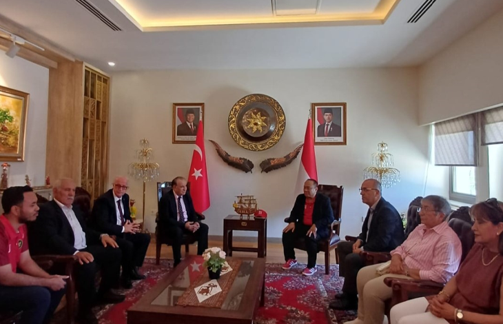 Görselde, Endonezya Büyükelçiliği’nde gerçekleştirilen görüşmede bir grup katılımcı karşılıklı koltuklarda oturuyor. Ortamda Türk ve Endonezya bayrakları ile iki ülkeyi temsil eden çeşitli semboller bulunuyor.