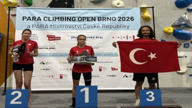 Görme Engelli Milli Sporcusu Fatih Güney üçüncü basamakta yer alırken, birinci ve ikinci basamakta bulunan kadın sporcuların yanında Türk bayrağı tutarak poz veriyor.