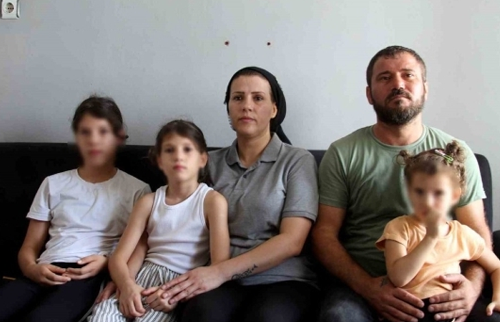 Ayşegül, annesi, babası ve iki kardeşiyle birlikte evde koltukta otururken görülüyor. Aile kameraya doğru bakıyor.