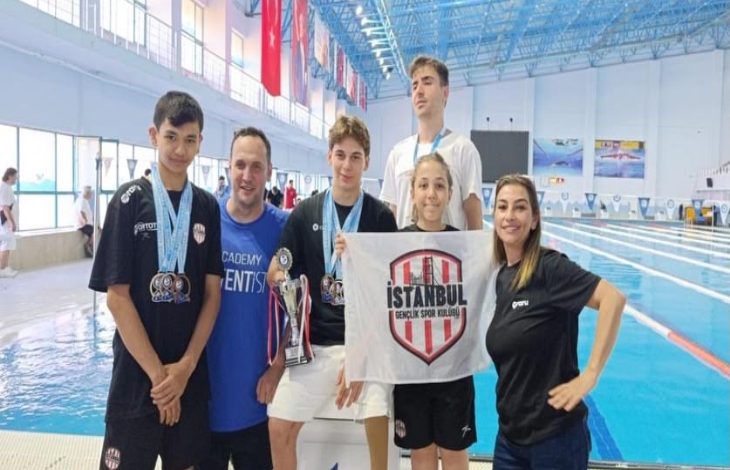 İstanbul Gençlik Spor Kulübü sporcuları ile antrenörleri kazanılan kupa ve madalyalarla poz veriyor.