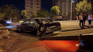 Ağır hasar görmüş siyah bir otomobilin çekiciye yüklenirken çevresinde birkaç kişinin beklediği ve olayın kaza sonrası müdahale aşamasında olduğu görülüyor.