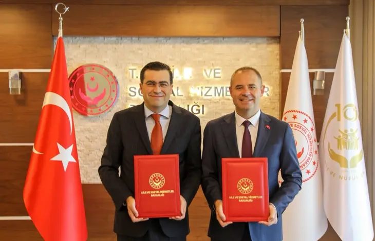 Aile ve Sosyal Hizmetler Bakanlığı Engelli ve Yaşlı Hizmetleri Genel Müdürü Taha Kürşad Sezen ile Kırklareli Belediye Başkanı Derya Bulut, ayakta durarak protokolleri ise ellerinde tutarak poz veriyor.