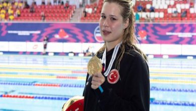 Milli Para Yüzücü Defne Kurt, boynunda duran altın madalyayı tutarak poz veriyor.