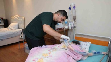 Murat Tayam, yatağında yatan annesine tıbbi müdahalede bulunurken görülüyor.