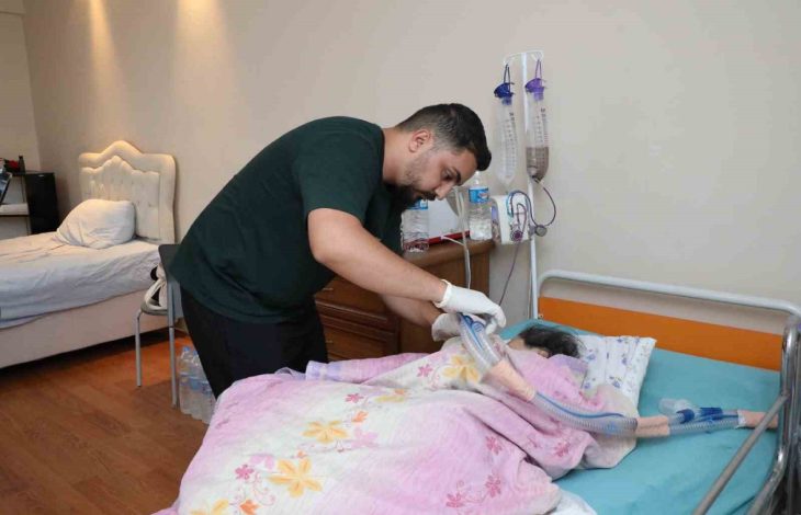 Murat Tayam, yatağında yatan annesine tıbbi müdahalede bulunurken görülüyor.