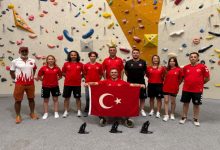 Fotoğrafta, tırmanış duvarının önünde kırmızı-beyaz Türk milli takım formaları giyen bir grup sporcu ve görevli, ortada Türk bayrağı tutan tekerlekli sandalyedeki bir sporcu ile birlikte gururla poz veriyor.